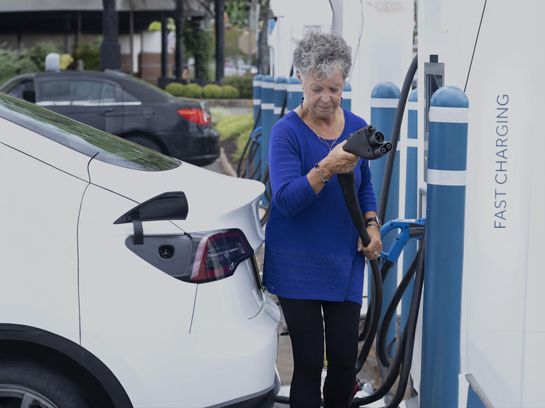 A woman at an EV charge point in the US