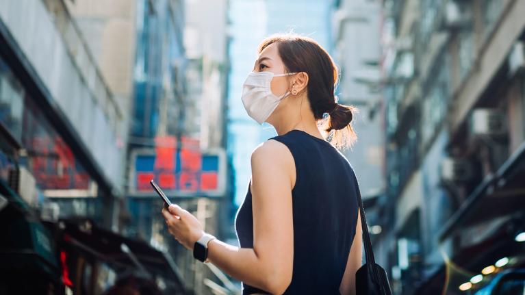 HEREの位置測位システムを駆使し、海外旅行中もスマートフォンで正確な位置情報を検索する女性