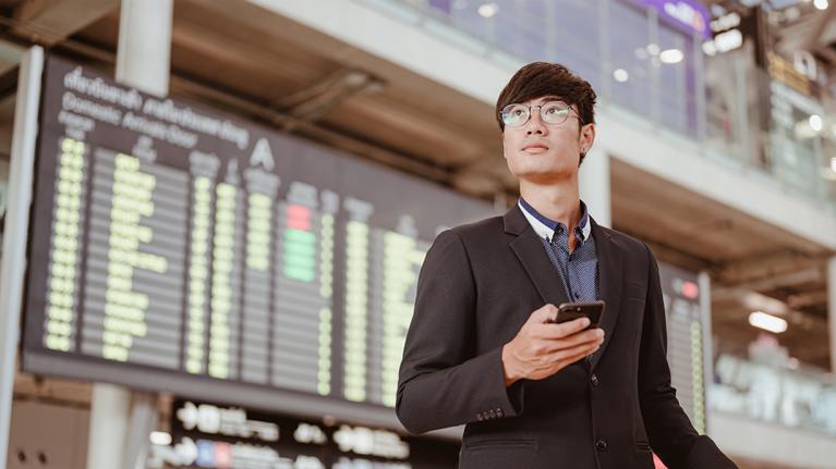 person in station holding mobile phone