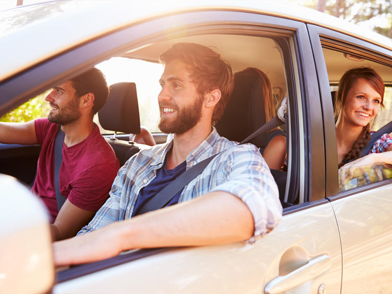 A group of friends on vacation driving in a car.