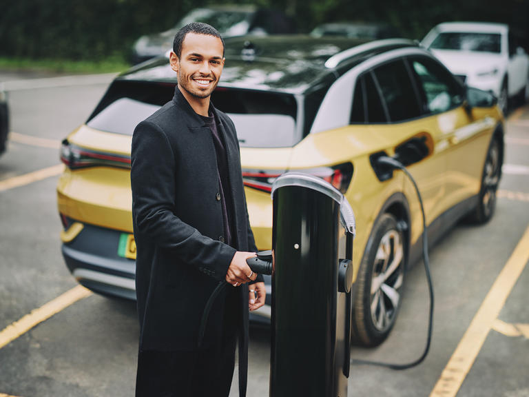 A man charges his electric vehicle at an EV chargepoint.