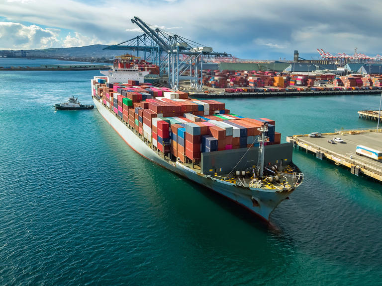 A large container ship docks at a shipping port.