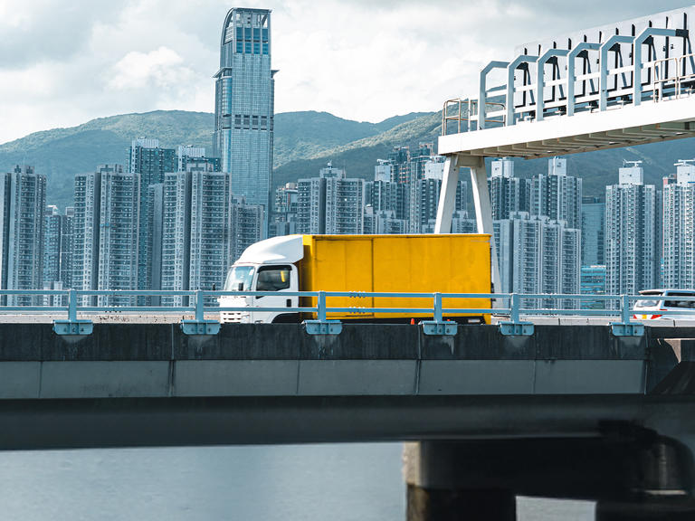 A truck driving on an overpass in the APAC region.