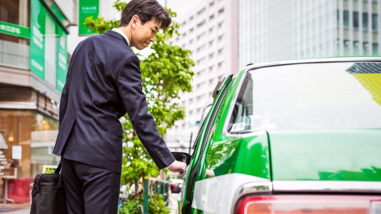 MaaSで快適なタクシー移動をする男性