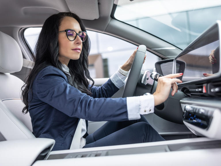 A woman sitting in her vehicle preparing for her journey ahead.
