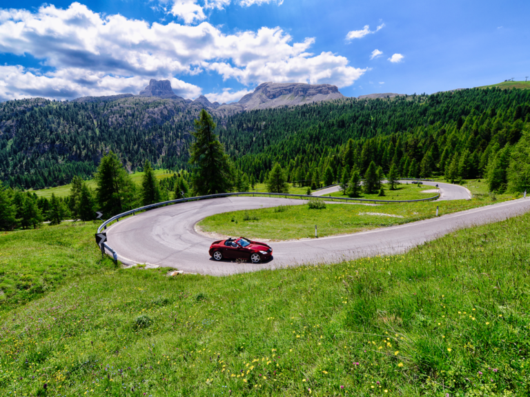 A car travels on a mountainous road.