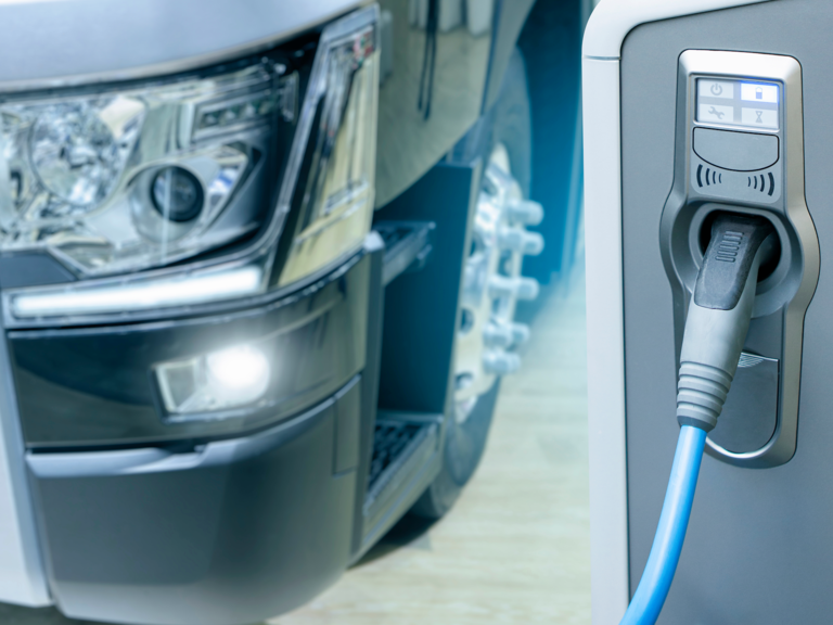 An electric truck docked at an EV charge station.